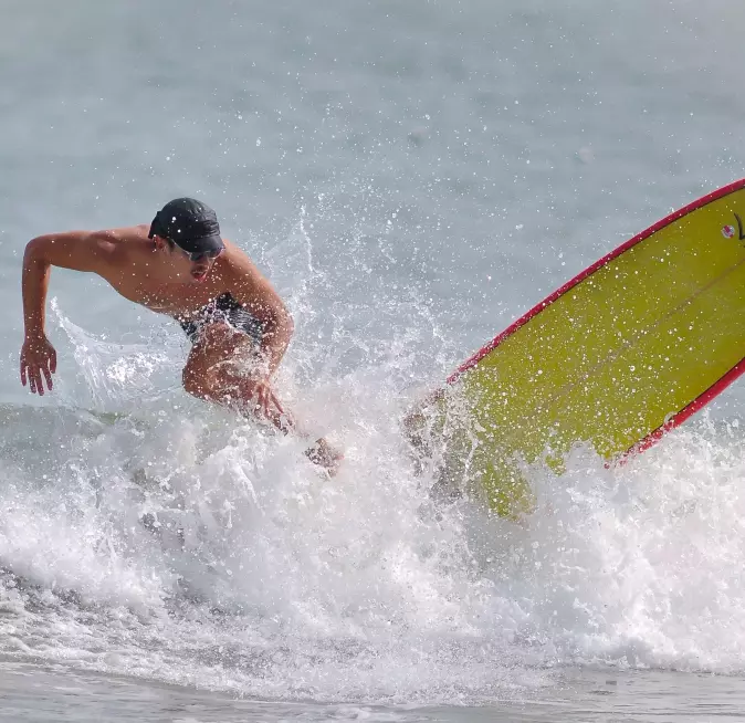 Man skillfully surfing a wave on yellow board