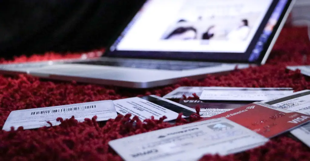 Laptop on rug with scattered event tickets and credit cards